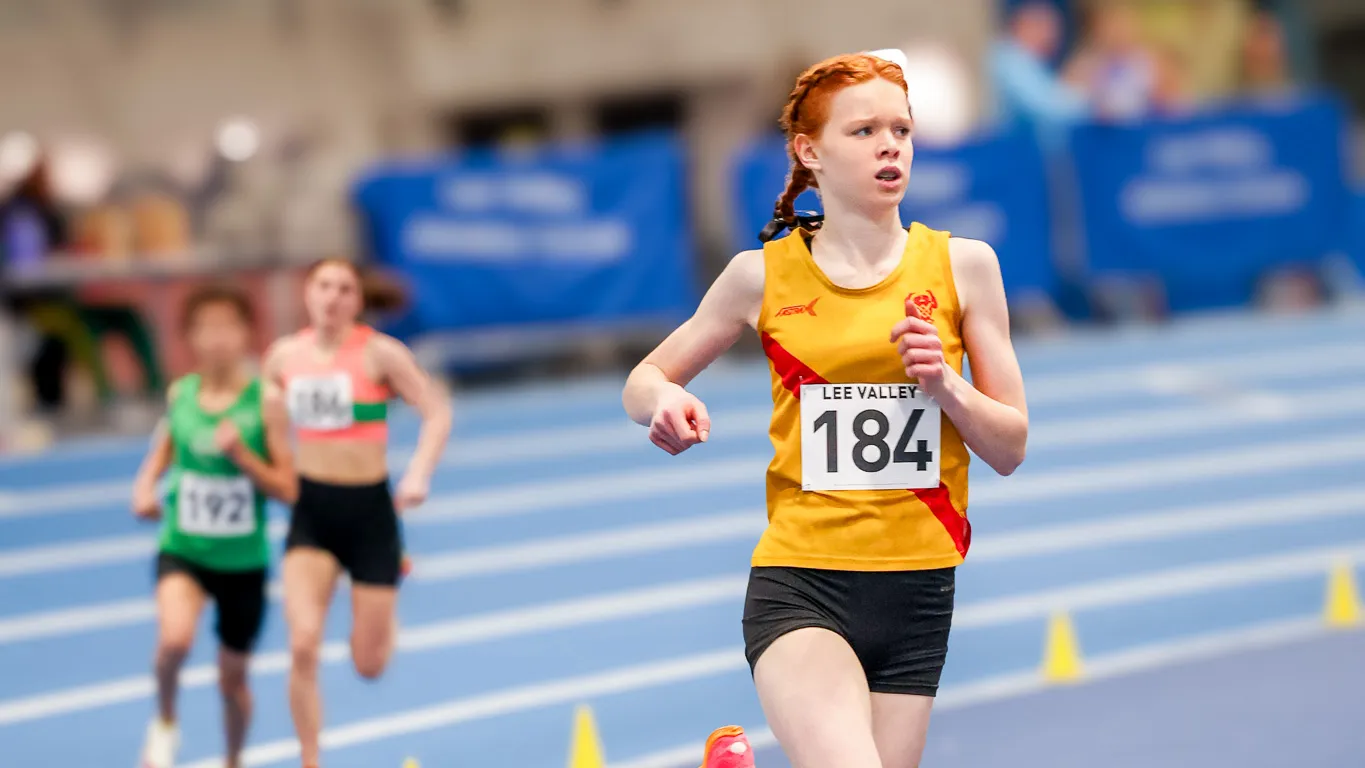 SpeedPro athlete racing on the bend of the indoor track at Lee Valley Athletics Centre
