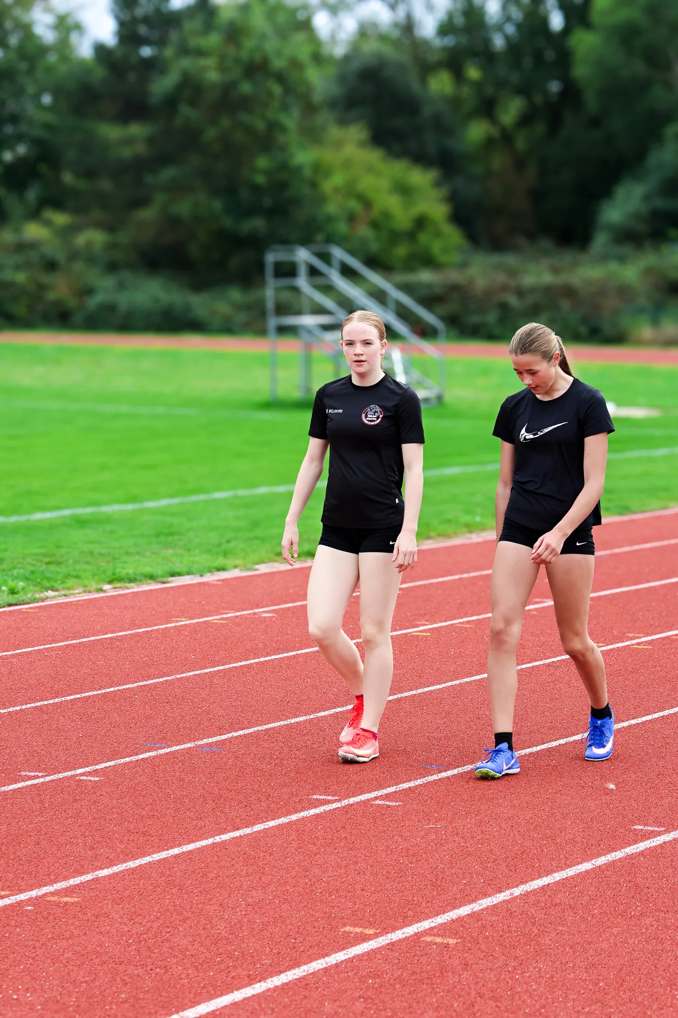 SpeedPro athletes Amelia Barnes and Lucy Whorton walking back between reps during a sprint training session on the track